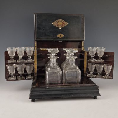 bottles and glasses in a wooden case on a table
