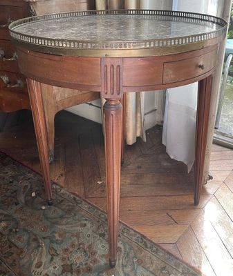 a round table with a marble top on a rug