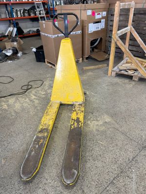 a fork lifter sitting on the ground in a warehouse