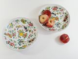 two bowls of fruit sitting on a table next to each other