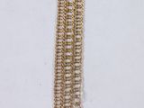 a close up of a gold chain bracelet with a coin on it
