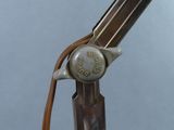 a close up of a gun with a leather handle