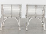 pair of white wicker chairs in the style of the early 20th century