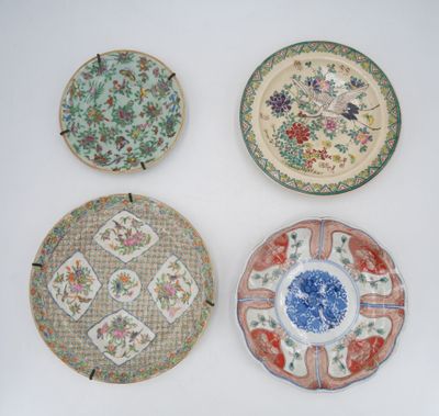 four chinese plates with floral designs on them on a white surface