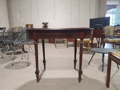 des tables et des chaises dans une pièce où l'on aperçoit de nombreux meubles en arrière-plan