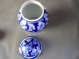 a blue and white vase with a lid sitting on a table