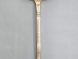 a silver spoon with a spoon handle sitting on top of a table