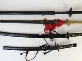 trois sabres de samouraï avec un cordon rouge et une paire de ciseaux