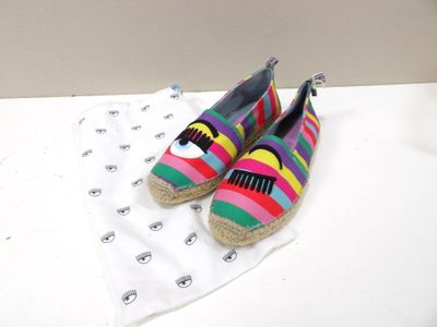 une paire de chaussures rayées aux couleurs vives posées sur une surface blanche