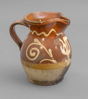 un vase marron et blanc posé sur une surface grise
