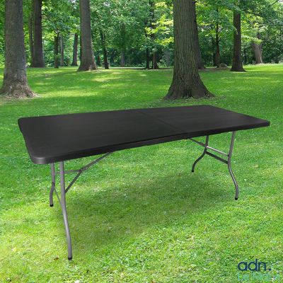 a black table in the middle of a grassy field
