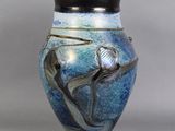 un vase bleu orné d'un oiseau, posé sur une table
