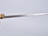 a sword with a gold handle on a white surface