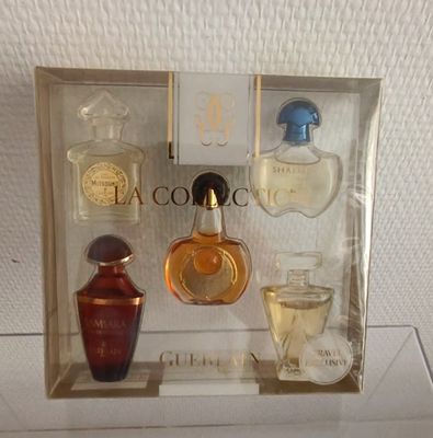 des flacons de parfum dans une vitrine posée sur un support blanc