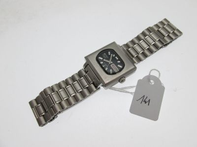 une montre en argent, munie d'une étiquette, posée sur une table