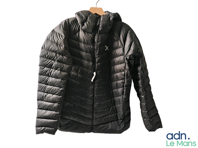 a black jacket hanging on a hanger on a white wall
