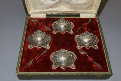 four silver spoons in a red velvet case