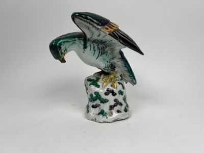 une figurine représentant un oiseau perché sur un rocher