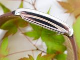 a close up of a ring with a leaf in the background
