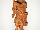 a wooden statue of a man holding a torch in his hand