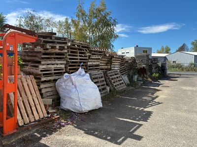 une pile de palettes et un sac de bois au bord de la route