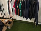 a room with a rack of clothes and a box of clothes