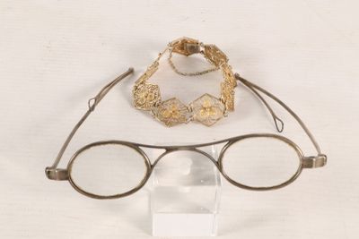 a pair of glasses and a bracelet sitting on a table