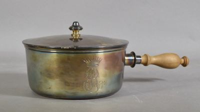 a metal pot with a wooden handle on a table