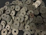 a pile of old silver coins on a black surface