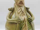 une figurine en céramique représentant un homme portant un chapeau et une barbe