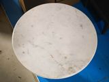 a white marble table with a blue chair in the background