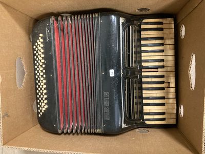 an accordion in a cardboard box sitting on top of a table