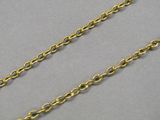 a close up of a gold chain on a gray surface