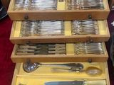beaucoup d'argenterie dans une boîte en bois posée sur une table