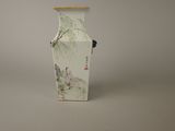 a vase with a painting on it sitting on a table