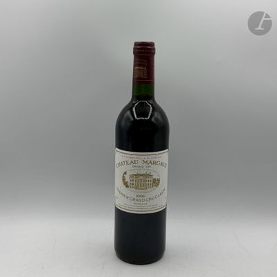 une bouteille de vin rouge posée sur une table blanche, sur fond gris