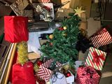 a pile of presents and a christmas tree in a garage