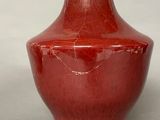 a red vase that is sitting on a table