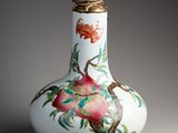 un vase blanc orné d'un oiseau et de fleurs