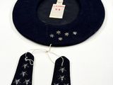 un chapeau noir orné d'étoiles argentées, à côté d'une paire d'étiquettes