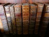 de nombreux livres anciens alignés sur une étagère dans une pièce