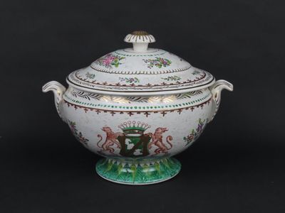a white and green bowl with a lid on a black background