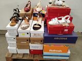 de nombreuses boîtes de chaussures posées sur une palette dans une pièce