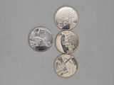 four different coins sitting on top of a table next to each other