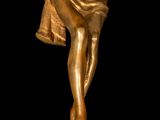 gold statue of a man holding a bell on a black background