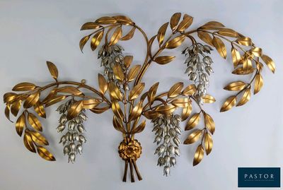sculpture murale en feuille d'or rehaussée de cristaux sur un mur blanc