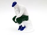 figurine of a man sitting on a toilet with his hands on his knees