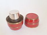 two small red containers with silver lids on a white surface