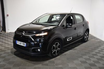 La Citroën noire est garée dans le garage, sur un sol à damier.