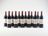 six bottles of red wine lined up in a row on a white surface